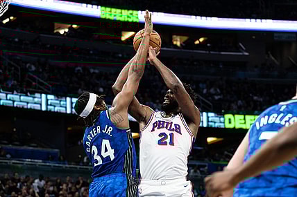 Jan 19, 2024; Orlando, Florida, USA; Philadelphia 76ers center Joel Embiid (21) shoots the ball over Orlando Magic center Wendell Carter Jr. (34) in the second quarter at KIA Center. Mandatory Credit: Jeremy Reper-USA TODAY Sports
