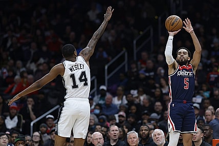 Jan 20, 2024; Washington, District of Columbia, USA; Washington Wizards guard Tyus Jones (5) shoots the ball as San Antonio Spurs guard Blake Wesley (14) defends in the second quarter at Capital One Arena. Mandatory Credit: Geoff Burke-USA TODAY Sports