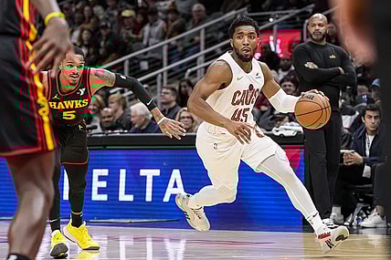 Jan 20, 2024; Atlanta, Georgia, USA; Cleveland Cavaliers guard Donovan Mitchell (45) dribbles past Atlanta Hawks guard Dejounte Murray (5) during the first half at State Farm Arena. Mandatory Credit: Dale Zanine-USA TODAY Sports
