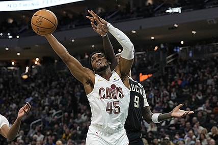 Jan 26, 2024; Milwaukee, Wisconsin, USA;  Cleveland Cavaliers guard Donovan Mitchell (45) reaches for a rebound in front of Milwaukee Bucks forward Bobby Portis (9) during the second quarter at Fiserv Forum. Mandatory Credit: Jeff Hanisch-USA TODAY Sports