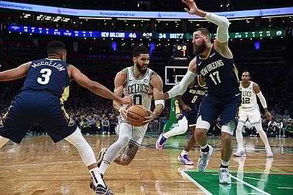 Jan 29, 2024; Boston, Massachusetts, USA;  Boston Celtics forward Jayson Tatum (0) moves to the basket while New Orleans Pelicans guard CJ McCollum (3) and center Jonas Valanciunas (17) defend during the first half at TD Garden. Mandatory Credit: Bob DeChiara-USA TODAY Sports