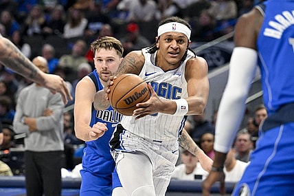 Jan 29, 2024; Dallas, Texas, USA; Orlando Magic forward Paolo Banchero (5) drives to the basket past Dallas Mavericks guard Luka Doncic (77) during the first quarter at the American Airlines Center. Mandatory Credit: Jerome Miron-USA TODAY Sports