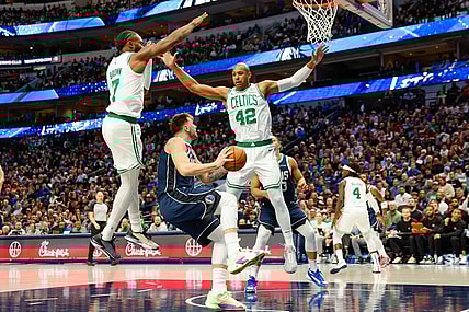 Jan 22, 2024; Dallas, Texas, USA; Dallas Mavericks guard Luka Doncic (77) looks to shoot with Boston Celtics center Al Horford (42) and guard Jaylen Brown (7) defending during the third quarter at American Airlines Center. Mandatory Credit: Andrew Dieb-USA TODAY Sports