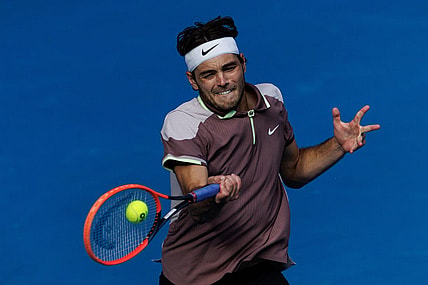 Jan 23, 2024; Melbourne, Victoria, Australia;  Taylor Fritz of the United States in action against Novak Djokovic of Serbia in the quarter final of the men s singles. Mandatory Credit: Mike Frey-USA TODAY Sports