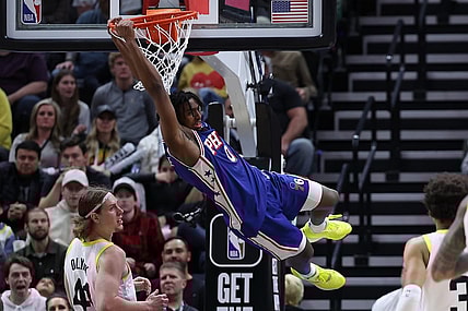 Feb 1, 2024; Salt Lake City, Utah, USA; Philadelphia 76ers guard Tyrese Maxey (0) hangs on the rim after a dunk against the Utah Jazz during the fourth quarter at Delta Center. Mandatory Credit: Rob Gray-USA TODAY Sports