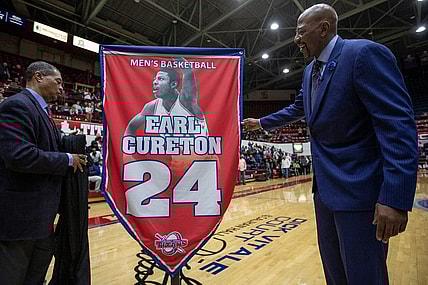 Detroit Mercy athletic director Robert C. Vowels, Jr., left, and Earl Cureton, unveil the No. 24 jersey retirement during the ceremony at Calihan Hall in Detroit, Thursday, Jan. 23, 2020.