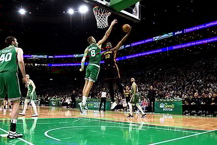 Feb 7, 2024; Boston, Massachusetts, USA;  Atlanta Hawks forward De'Andre Hunter (12) drives to the basket and gets fouled by Boston Celtics center Kristaps Porzingis (8) during the first half at TD Garden. Mandatory Credit: Bob DeChiara-USA TODAY Sports