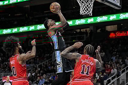 Feb 12, 2024; Atlanta, Georgia, USA; Atlanta Hawks forward Onyeka Okongwu (17) scores a basket over Chicago Bulls forward DeMar DeRozan (11) during the first half at State Farm Arena. Mandatory Credit: Dale Zanine-USA TODAY Sports