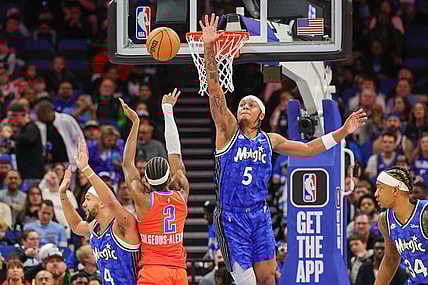 Feb 13, 2024; Orlando, Florida, USA; Oklahoma City Thunder guard Shai Gilgeous-Alexander (2) shoots the ball over Orlando Magic forward Paolo Banchero (5) during the first quarter at Amway Center. Mandatory Credit: Mike Watters-USA TODAY Sports