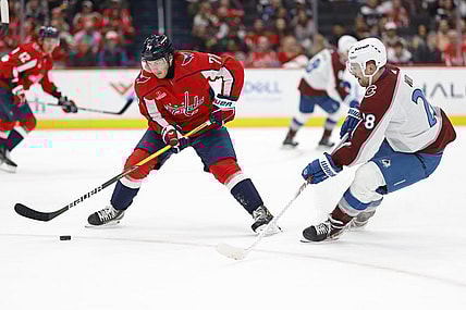 Feb 13, 2024; Washington, District of Columbia, USA; Washington Capitals right wing T.J. Oshie (77) controls the puck as Colorado Avalanche left wing Miles Wood (28) defends in the second period at Capital One Arena. Mandatory Credit: Geoff Burke-USA TODAY Sports