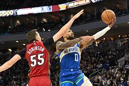 Feb 13, 2024; Milwaukee, Wisconsin, USA; Milwaukee Bucks guard Damian Lillard (0) drives to the basket against Miami Heat forward Duncan Robinson (55) in the first half at Fiserv Forum. Mandatory Credit: Michael McLoone-USA TODAY Sports