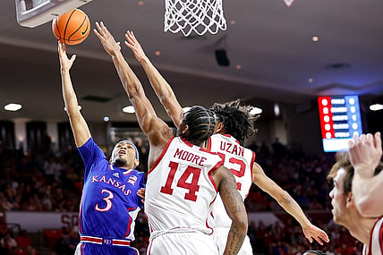Kansas guard Dajuan Harris Jr. (3) lays up the ball past Oklahoma guard Milos Uzan (12) and Oklahoma forward Jalon Moore (14) in the first half during an NCAA basketball game between The University of Oklahoma (OU) and The University of Kansas (KU), at the Lloyd Noble Center in Norman Okla., on Saturday, Feb. 17, 2024.