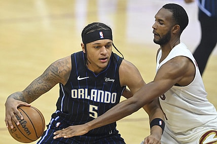 Feb 22, 2024; Cleveland, Ohio, USA; Orlando Magic forward Paolo Banchero (5) dribbles beside Cleveland Cavaliers forward Evan Mobley (4) in the first quarter at Rocket Mortgage FieldHouse. Mandatory Credit: David Richard-USA TODAY Sports