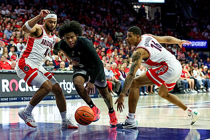 Feb 24, 2024; Tucson, Arizona, USA; Washington Huskies guard Sahvir Wheeler (5) drives to the basket against Arizona Wildcats guard Kylan Boswell (4) and forward Keshad Johnson (16) during the first half at McKale Center. Mandatory Credit: Zachary BonDurant-USA TODAY Sports