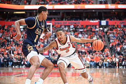 Feb 24, 2024; Syracuse, New York, USA; Syracuse Orange guard Judah Mintz (3) tries to move the ball past Notre Dame Fighting Irish forward Tae Davis (13) in the second half at the JMA Wireless Dome. Mandatory Credit: Mark Konezny-USA TODAY Sports
