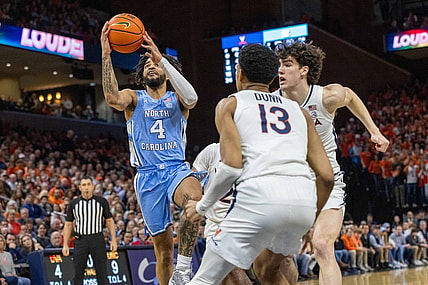 Feb 24, 2024; Charlottesville, Virginia, USA; North Carolina Tar Heels guard RJ Davis (4) attempts a shot while Virginia Cavaliers Ryan Dunn (13) and Blake Buchanan (0) defend him during the first half at John Paul Jones Arena. Mandatory Credit: Hannah Pajewski-USA TODAY Sports