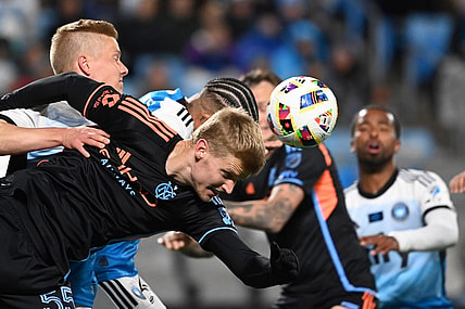 Feb 24, 2024; Charlotte, North Carolina, USA;  New York City midfielder Keaton Parks (55) heads the ball as Charlotte FC Junior Urso (30) defends in the first half at Bank of America Stadium. Mandatory Credit: Bob Donnan-USA TODAY Sports