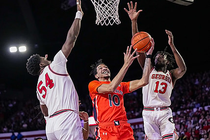 Feb 24, 2024; Athens, Georgia, USA; Auburn Tigers guard Chad Baker-Mazara (10) goes to the basket between Georgia Bulldogs center Russel Tchewa (54) and forward Dylan James (13) at Stegeman Coliseum. Mandatory Credit: Dale Zanine-USA TODAY Sports