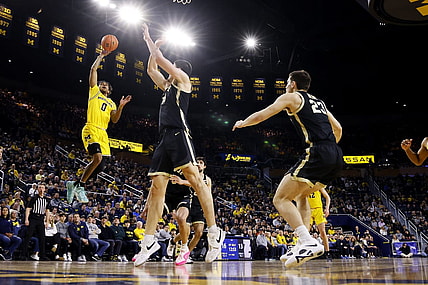 Feb 25, 2024; Ann Arbor, Michigan, USA;  Michigan Wolverines guard Dug McDaniel (0) shoots over Purdue Boilermakers center Zach Edey (15) in the first half at Crisler Center. Mandatory Credit: Rick Osentoski-USA TODAY Sports