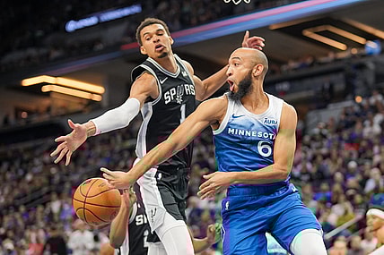 Feb 27, 2024; Minneapolis, Minnesota, USA; Minnesota Timberwolves guard Jordan McLaughlin (6) passes against the San Antonio Spurs center Victor Wembanyama (1) in the second quarter at Target Center. Mandatory Credit: Brad Rempel-USA TODAY Sports