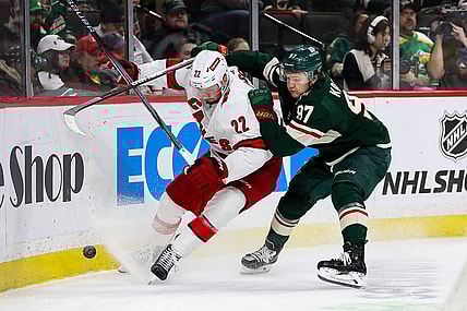 Feb 27, 2024; Saint Paul, Minnesota, USA; Carolina Hurricanes defenseman Brett Pesce (22) and Minnesota Wild left wing Kirill Kaprizov (97) compete for the puck during the second period at Xcel Energy Center. Mandatory Credit: Matt Krohn-USA TODAY Sports