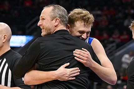 Mar 5, 2023; St. Louis, MO, USA; Drake Bulldogs guard Tucker DeVries (12) celebrates with head coach Darian DeVries during the second half against the Bradley Braves in the finals of the Missouri Valley Conference Tournament at Enterprise Center. Mandatory Credit: Jeff Curry-USA TODAY Sports