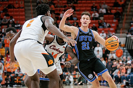 Feb 17, 2024; Stillwater, Oklahoma, USA; Brigham Young Cougars guard Trevin Knell (21) drives to the basket around Oklahoma State Cowboys guard Jamyron Keller (14) and Oklahoma State Cowboys forward Eric Dailey Jr. (2) during the second half at Gallagher-Iba Arena. Mandatory Credit: William Purnell-USA TODAY Sports
