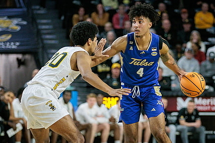 Feb 21, 2024; Wichita, Kansas, USA; Tulsa Golden Hurricane guard PJ Haggerty (4) brings the ball up court around Wichita State Shockers guard Harlond Beverly (20) during the second half at Charles Koch Arena. Mandatory Credit: William Purnell-USA TODAY Sports