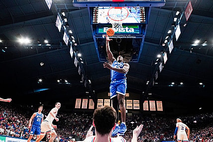 Feb 27, 2024; Lawrence, Kansas, USA; Brigham Young Cougars forward Fousseyni Traore (45) shoots as Kansas Jayhawks forward Parker Braun (23) falls below him during the second half at Allen Fieldhouse. Mandatory Credit: Denny Medley-USA TODAY Sports
