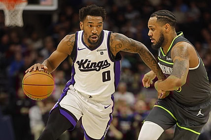Mar 1, 2024; Minneapolis, Minnesota, USA; Sacramento Kings guard Malik Monk (0) works around Minnesota Timberwolves guard Monte Morris (23) in the first quarter at Target Center. Mandatory Credit: Bruce Kluckhohn-USA TODAY Sports