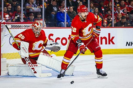 Mar 4, 2024; Calgary, Alberta, CAN; Calgary Flames defenseman MacKenzie Weegar (52) controls the puck in front of Calgary Flames goaltender Jacob Markstrom (25) during the first period against the Seattle Kraken at Scotiabank Saddledome. Mandatory Credit: Sergei Belski-USA TODAY Sports