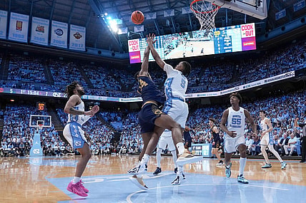 Mar 5, 2024; Chapel Hill, North Carolina, USA; Notre Dame Fighting Irish forward Kebba Njie (14) has his shot blocked by North Carolina Tar Heels forward Armando Bacot (5) during the first half at Dean E. Smith Center. Mandatory Credit: Jim Dedmon-USA TODAY Sports