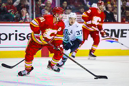 Mar 4, 2024; Calgary, Alberta, CAN; Calgary Flames center Nazem Kadri (91) controls the puck against the Seattle Kraken during the third period at Scotiabank Saddledome. Mandatory Credit: Sergei Belski-USA TODAY Sports