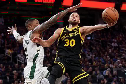 Mar 6, 2024; San Francisco, California, USA; Golden State Warriors guard Stephen Curry (30) shoots the ball while being defended by Milwaukee Bucks guard Damian Lillard (0) in the third quarter at the Chase Center. Mandatory Credit: Cary Edmondson-USA TODAY Sports