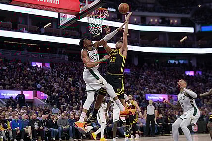 Mar 6, 2024; San Francisco, California, USA; Golden State Warriors forward Trayce Jackson-Davis (32) makes a shot over Milwaukee Bucks forward Giannis Antetokounmpo (34) in the third quarter at the Chase Center. Mandatory Credit: Cary Edmondson-USA TODAY Sports