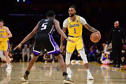 Mar 6, 2024; Los Angeles, California, USA; Los Angeles Lakers guard D'Angelo Russell (1) controls the ball against Sacramento Kings guard De'Aaron Fox (5) during the second half at Crypto.com Arena. Mandatory Credit: Gary A. Vasquez-USA TODAY Sports