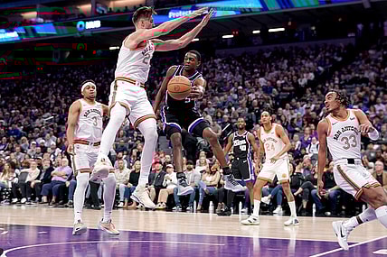 Mar 7, 2024; Sacramento, California, USA; Sacramento Kings guard De'Aaron Fox (5) passes the ball around the reach of San Antonio Spurs forward Zach Collins (23) in the second quarter at the Golden 1 Center. Mandatory Credit: Cary Edmondson-USA TODAY Sports