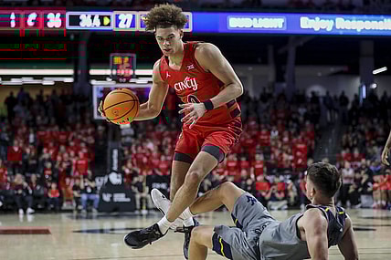 Mar 9, 2024; Cincinnati, Ohio, USA; Cincinnati Bearcats guard Dan Skillings Jr. (0) drives to the basket against West Virginia Mountaineers guard Kerr Kriisa (3) in the first half at Fifth Third Arena. Mandatory Credit: Katie Stratman-USA TODAY Sports