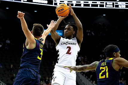 Cincinnati Bearcats guard Jizzle James (2) hits a 3-point basket as West Virginia Mountaineers guard Kerr Kriisa (3) defends in the first half of the Big 12 Conference tournament between Cincinnati Bearcats and West Virginia Mountaineers at T-Mobile Center in Kansas City, Mo., on Tuesday, March 12, 2024.