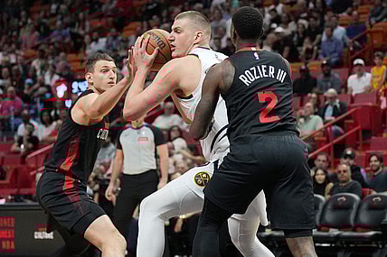 Mar 13, 2024; Miami, Florida, USA;  Denver Nuggets center Nikola Jokic (15) drives to the basket as Miami Heat guard Terry Rozier (2) and Miami Heat forward Nikola Jovic (5), right, defend during the first half at Kaseya Center. Mandatory Credit: Jim Rassol-USA TODAY Sports
