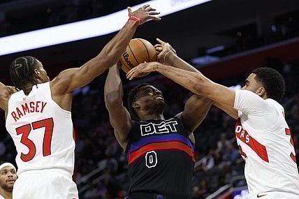 Mar 13, 2024; Detroit, Michigan, USA;  Detroit Pistons center Jalen Duren (0) grabs the rebound over Toronto Raptors guard Jahmi'us Ramsey (37) in the first half at Little Caesars Arena. Mandatory Credit: Rick Osentoski-USA TODAY Sports