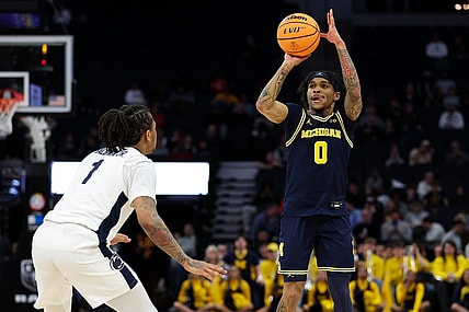Mar 13, 2024; Minneapolis, MN, USA; Michigan Wolverines guard Dug McDaniel (0) shoots as Penn State Nittany Lions guard Ace Baldwin Jr. (1) defends during the first half at Target Center. Mandatory Credit: Matt Krohn-USA TODAY Sports