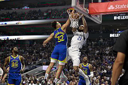 Mar 13, 2024; Dallas, Texas, USA; Dallas Mavericks center Daniel Gafford (21) dunks the ball past Golden State Warriors forward Trayce Jackson-Davis (32) during the first quarter at the American Airlines Center. Mandatory Credit: Jerome Miron-USA TODAY Sports