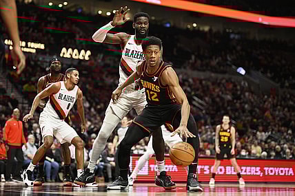 Mar 13, 2024; Portland, Oregon, USA; Atlanta Hawks forward De'Andre Hunter (12) dribbles the basketball during the second half against Portland Trail Blazers center Deandre Ayton (2) at Moda Center. Mandatory Credit: Troy Wayrynen-USA TODAY Sports