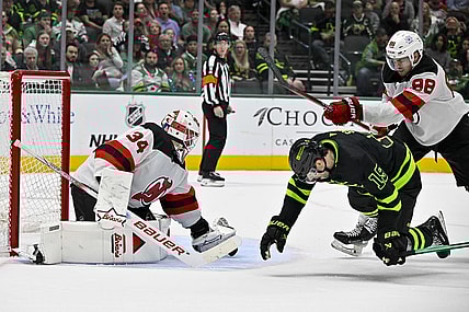 Mar 14, 2024; Dallas, Texas, USA; New Jersey Devils defenseman Kevin Bahl (88) is called for a cross check on Dallas Stars left wing Jamie Benn (14) as goaltender Jake Allen (34) covers the puck during the second period at the American Airlines Center. Mandatory Credit: Jerome Miron-USA TODAY Sports