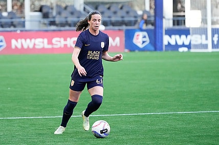 Mar 17, 2024; Seattle, Washington, USA; Seattle Reign defender Phoebe McClernon (21) dribbles against the Washington Spirit during the first half at Lumen Field. Mandatory Credit: Stephen Brashear-USA TODAY Sports