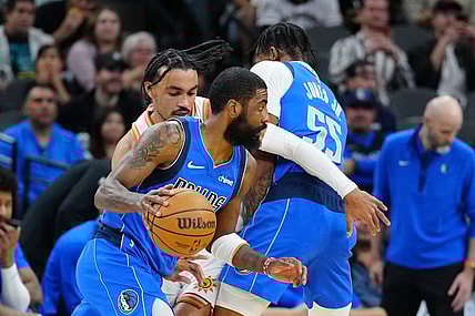 Mar 19, 2024; San Antonio, Texas, USA;  Dallas Mavericks guard Kyrie Irving (11) dribbles past San Antonio Spurs guard Tre Jones (33) in the first half at Frost Bank Center. Mandatory Credit: Daniel Dunn-USA TODAY Sports