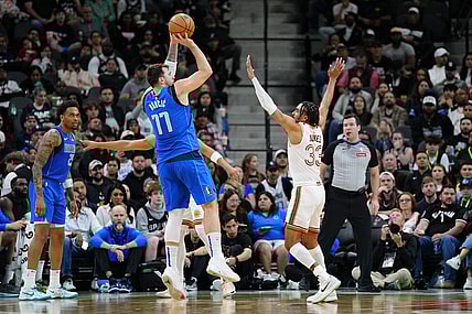 Mar 19, 2024; San Antonio, Texas, USA;  Dallas Mavericks guard Luka Doncic (77) shoots over San Antonio Spurs guard Tre Jones (33) in the first half at Frost Bank Center. Mandatory Credit: Daniel Dunn-USA TODAY Sports