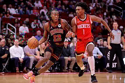Mar 21, 2024; Houston, Texas, USA; Chicago Bulls guard Ayo Dosunmu (12) handles the ball against Houston Rockets forward Amen Thompson (1) during the second quarter at Toyota Center. Mandatory Credit: Erik Williams-USA TODAY Sports