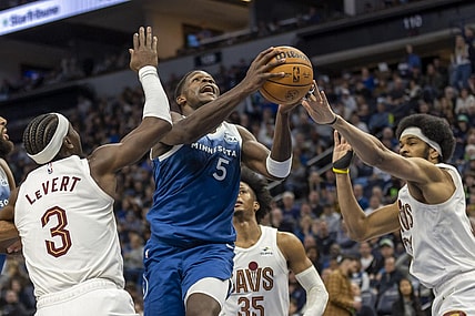 Mar 22, 2024; Minneapolis, Minnesota, USA; Minnesota Timberwolves guard Anthony Edwards (5) drives to the basket past Cleveland Cavaliers center Jarrett Allen (31) and Cleveland Cavaliers guard Caris LeVert (3) in the second half at Target Center. Mandatory Credit: Jesse Johnson-USA TODAY Sports